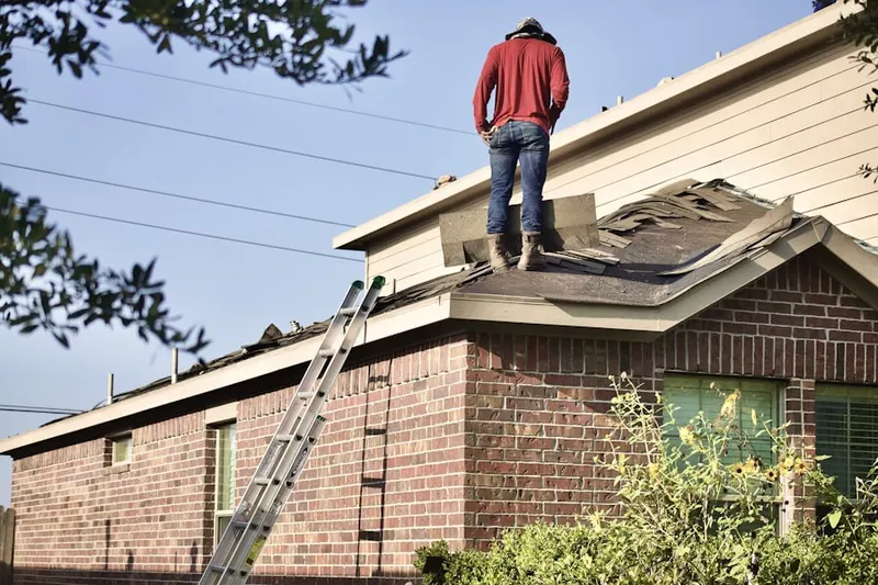 Professional roofer working on a residential roof in Scott